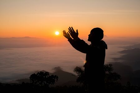 Silhouette of christian man hand praying,spirituality and religion,man praying to god. Christianity...