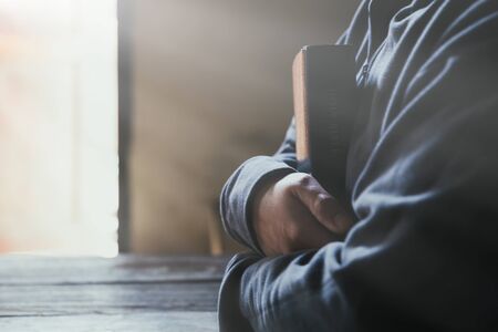 Hands folded in prayer on a Holy Bible in church concept for faith, spirituality and religion, woman praying on holy bible in the morning. woman hand with Bible praying.の写真素材