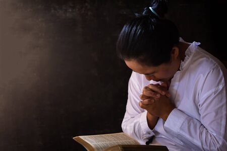 Christian life crisis prayer to god. Woman Pray for god blessing to wishing have a better life. woman hands praying to god with the bible. begging for forgiveness and believe in goodness.の写真素材