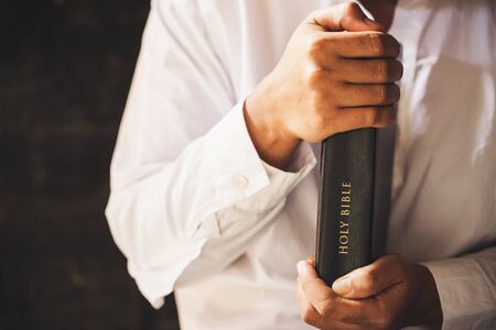 Hands folded in prayer on a Holy Bible in church concept for faith, spirituality and religion, woman praying on holy bible in the morning. woman hand with Bible praying.の写真素材