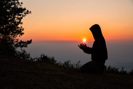 Silhouette of christian man hand praying, spirituality and religion, man praying to god. Christianity concept.の写真素材