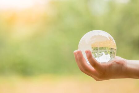 Hands Holding Globe Glass In Green Forest - Environment Conceptの写真素材