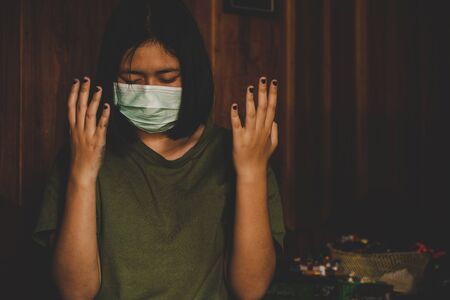 teen girl wearing mask for protect pm2.5 and Covid-19. She praying in the morning for a new day freedom to corona virus. Asian girl hand praying for thank GOD. Copy space.の写真素材