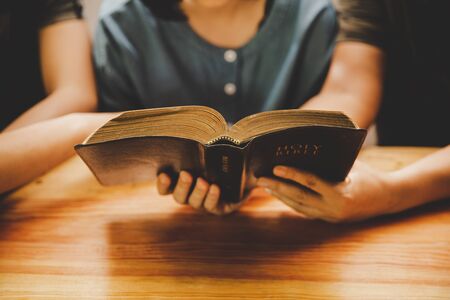Christian family worship God in home, Holy bible on wooden table concept for faith, spirituality, worship and religion.の写真素材