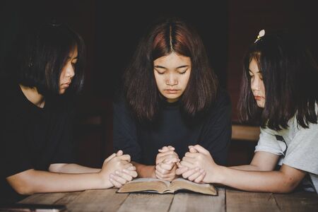 Group of people praying worship believe. soft focus, praying and praise together at home. devotional or prayer meeting concept.の写真素材