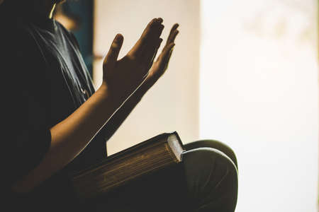 Teenage girl hand with Bible praying in the morning. concept for faith, spirituality and religionの写真素材