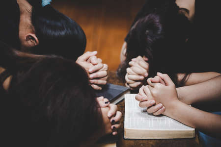 Group of people praying worship believe. soft focus, praying and praise together at home. devotional or prayer meeting concept.の写真素材
