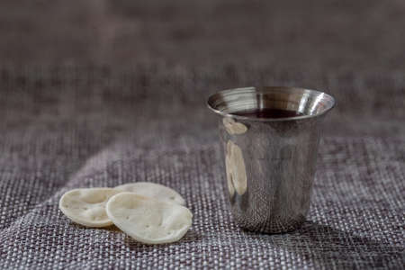 Pray with holding loaf and little cup of the wine. adult and faithful in Jesus Christ woman in a holy communion.の写真素材