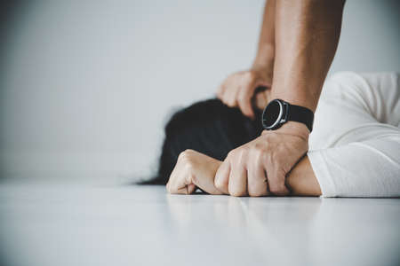 Close up of man hands holding a woman hands for rape and sexual abuse concept.の写真素材