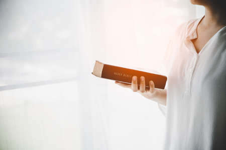 Christian teenage girl holds bible in her hands. Concept for faith, spirituality and religion. Peace, hope.の写真素材