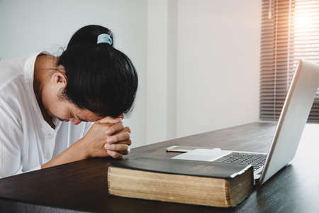 Woman girl stay at home pray and worship GOD with laptop.の写真素材