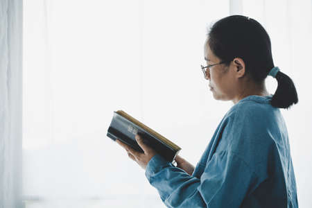 Christian girl holds bible in her hands. Concept for faith, spirituality and religion. Peace, hope.