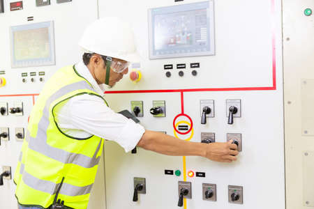 Maintenance engineers inspect relay protection system. Bay control unit. Medium voltage switchgear