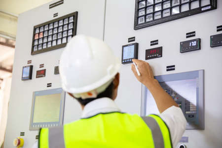 Close-up Of A Electrician Examining A Fusebox. Man taking readings of an electric meterの写真素材