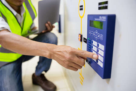 Electrician engineer work at Relay protection system. Bay control unit. Medium voltage switchgear....