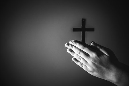 Image black and white woman hand holding cross and praying to God at church.