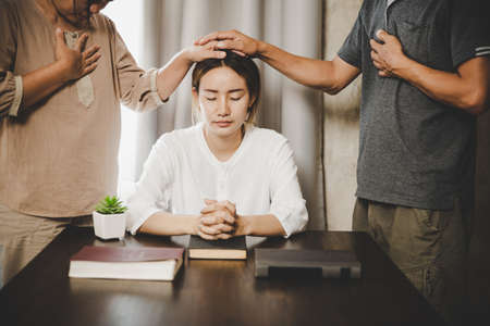 Group of people praying worship believe. soft focus, praying and praise together at home. devotional...