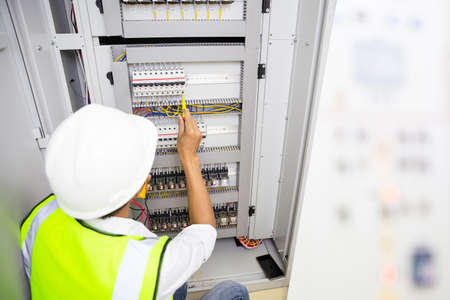 Electrician engineer work tester measuring voltage and current of power electric line in electical...