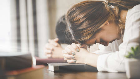 Two women praying worship believe. soft focus, praying and praise together at home. devotional or prayer meeting concept.の写真素材
