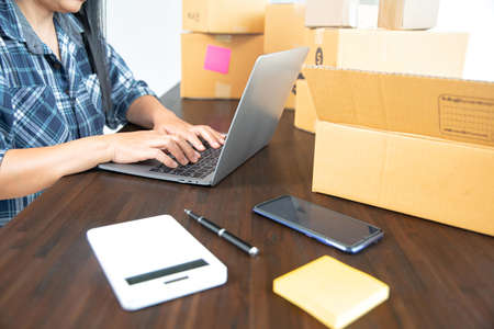Small entrepreneurs start their SME business at home by arranging their products in parcel boxes. The idea is to start selling online with laptops for taking orders and shipping.の写真素材