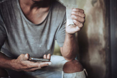 Man is drug dealer. Man call up sells the drugs on phone and he is addicted drug or narcotic with copy spaceの写真素材