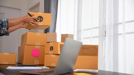 Closeup view of female online store small business owner seller entrepreneur packing package post...