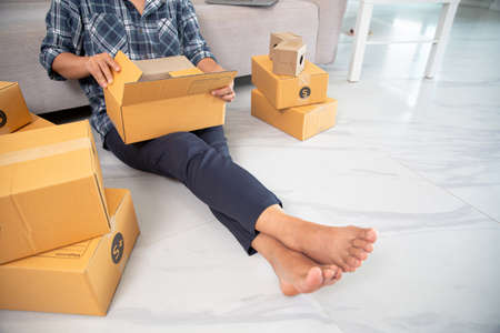 Closeup view of female online store small business owner seller entrepreneur packing package post...