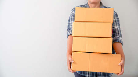 Asian female entrepreneur holding cardboard boxes. copy space. Fast and free Delivery transport . Online shopping and Express delivery.の写真素材