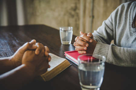 Christians are congregants join hands to pray and seek the blessings of God, the Holy Bible. They were reading the Bible and sharing the gospel with copy space.の写真素材