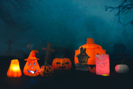 Halloween pumpkin head jack lantern with burning candles. Pumpkins in graveyard in the spooky night - halloween backdropの写真素材
