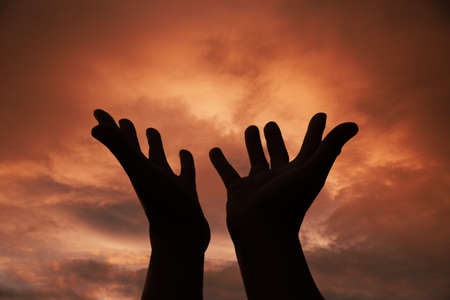 Person human hands open palm up worship or pray for god. background is sunrise. Concept for...