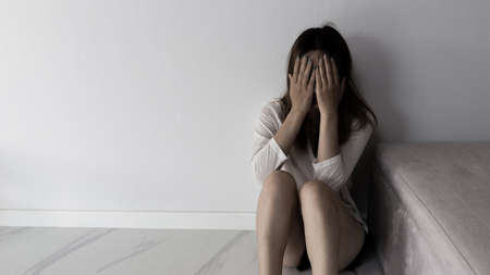 Young person woman sad, stress and loneliness sitting in dark room, Unhappy and crying teenage girl...