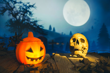 Skull and spooky cemetery with glow halloween pumpkin in the nightの写真素材