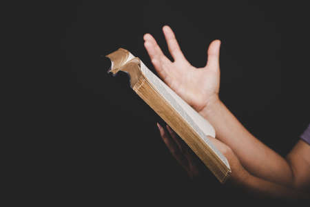Close up of christian woman hand holding holy bible pray and worship for thank god in church with...