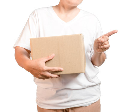 A parcel cardboard parcel box in a delivery woman person hands isolated on white background. Delivery service concept. Asian Young girl holding a package is a delivery business entrepreneur.の写真素材