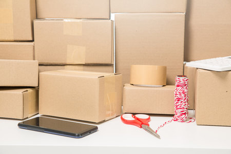 Equipments for SME online business, delivery business laptop, barcode, boxes, checking product on stocks or cardboard parcels. Small business working at home office. delivery service product at home.の写真素材