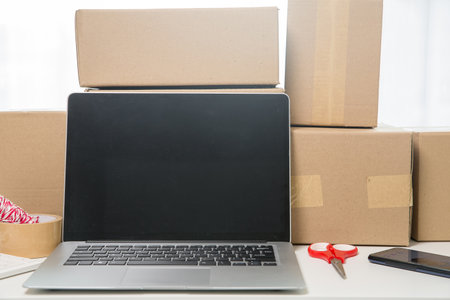 Equipments for SME online business, delivery business laptop, barcode, boxes, checking product on stocks or cardboard parcels. Small business working at home office. delivery service product at home.の写真素材