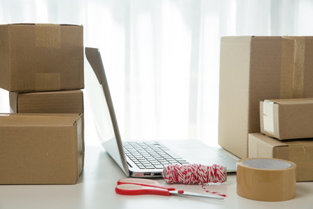 Equipments for SME online business, delivery business laptop, barcode, boxes, checking product on stocks or cardboard parcels. Small business working at home office. delivery service product at home.の写真素材