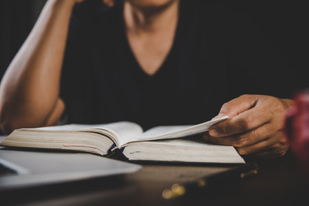 Young woman person hand holding holy bible with study at home. Adult female christian reading book in church. Girl learning religion spirituality with pray to god. concept of student education faith.の写真素材