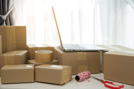 Equipments for SME online business, delivery business laptop, barcode, boxes, checking product on stocks or cardboard parcels. Small business working at home office. delivery service product at home.の写真素材