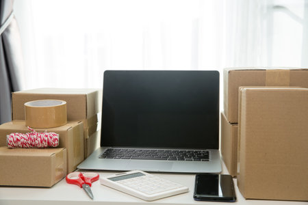 Equipments for SME online business, delivery business laptop, barcode, boxes, checking product on stocks or cardboard parcels. Small business working at home office. delivery service product at home.の写真素材