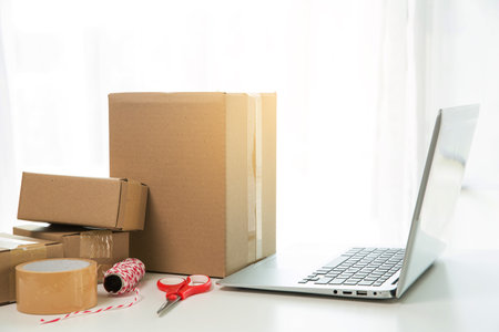 Equipments for SME online business, delivery business laptop, barcode, boxes, checking product on stocks or cardboard parcels. Small business working at home office. delivery service product at home.の写真素材