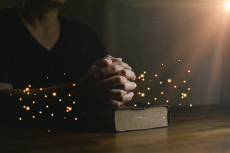 Prayer person hand in black background. Christian catholic woman are praying to god in dark at church. Girl believe and faith in jesus christ. Christ religion and christianity worship or pray concept.の写真素材