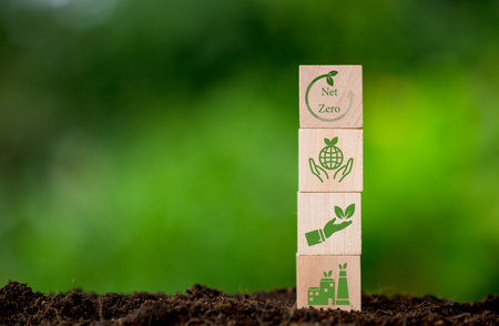 Net zero and carbon neutral concept. Net zero greenhouse gas emissions target. Climate neutral long term strategy. Wooden cubes with green net zero icon and green conserve icon on nature background.の写真素材