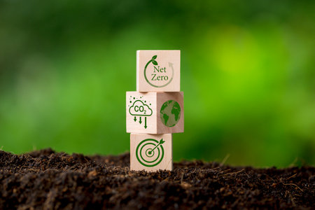 Net zero and carbon neutral concept. Net zero greenhouse gas emissions target. Climate neutral long term strategy. Wooden cubes with green net zero icon and green conserve icon on nature background.の写真素材