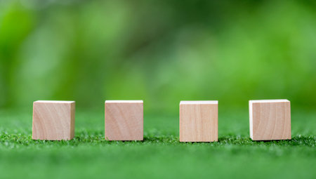 Stacking blank wooden cubes on green background with copy space for input wording and infographic icon. Empty brown wooden object block for symbol icon put technology, zero gravity, business concept.の写真素材