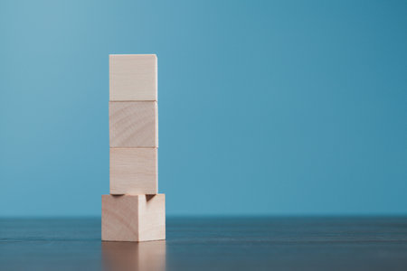 Stacking blank wooden cubes on blue background with copy space for input wording and infographic icon. Empty brown wooden object block for symbol icon put technology, zero gravity, business concept.の写真素材