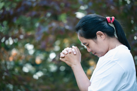 Prayer person hand in black background. Christian catholic woman are praying to god in dark at...