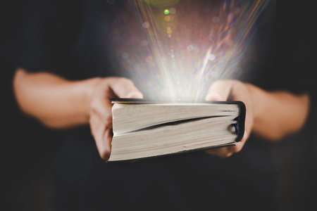 Young woman person hand holding holy bible with study at home. Adult female christian reading book in church. Girl learning religion spirituality with pray to god. concept of student education faith.の写真素材