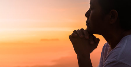 Silhouette of woman hand praying spirituality and religion, female worship to god. Christianity religion concept. Religious people are humble to God. Christians have hope faith and faith in god.の写真素材